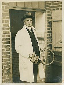 Man in White Coat Holding Tool device old Photo 1920's
