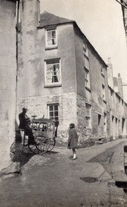 England? Girl watching Knifegrinder at work Village Street Old Photo 1920